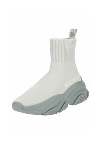 Witte gebreide sneaker in sokstijl met een geribde boord, grijze rubberen zool en textuurpatronen. Bevat "STEVE MADDEN" merknaam aan de zijkant.