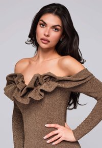 Hnědress, bez ramínek, s volánovým dekoltem. Dlouhé rukávy a přiléhavý střih, vyrobený z texturované tkaniny s jemným leskem.