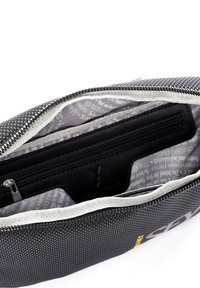Borsa in tessuto nero con texture, dotata di zip argentata, fodera interna grigia con testo e una tasca con zip separata su un lato.