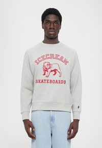 Lysegrå sweatshirt med en rød grafik af en bulldog og teksten "ICECREAM SKATEBOARDS". Ribbet ved håndleddene og nederst, afslappet fit.