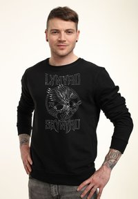 Černá mikina s grafickým designem stříbrného orla a kytary a textem "LYNYRD SKYNYRD." Pohodlný střih s ribbed manžetami.