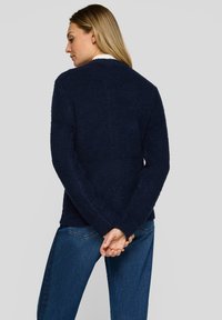 Marineblauer, strukturierter Fleecepullover mit langen Ärmeln, rundem Ausschnitt und lockerem Schnitt. Verfügt über ein schlichtes Design ohne Verzierungen.