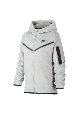 Jasnoszara kurtka z kapturem i zamkiem błyskawicznym Nike z czarnym logo, ukośnymi czarnymi paskami na piersi oraz kieszenią na zamek na lewym rękawie.