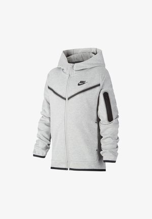 Jasnoszara kurtka z kapturem i zamkiem błyskawicznym Nike z czarnym logo, ukośnymi czarnymi paskami na piersi oraz kieszenią na zamek na lewym rękawie.