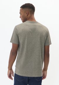 Gray striped t-shirt with short sleeves, featuring a rounded neckline and soft texture, worn with dark blue jeans.