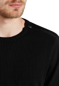 Czarny prążkowany sweter z dzianiny z okrągłym dekoltem oraz bocznym zamkiem błyskawicznym na ramieniu, pełniącym funkcję ozdobnego akcentu.