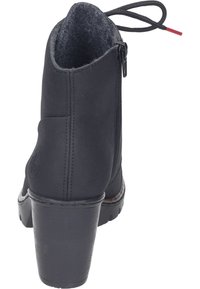 Botín negro hasta el tobillo con punta redondeada, cremallera lateral y tacón texturizado. Presenta un forro de tela y acentos cosidos a lo largo de la suela.