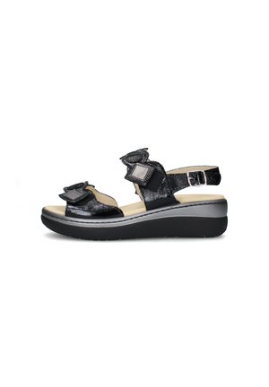 Sandalo zeppa in pelle verniciata nera con cinturini regolabili, soletta beige imbottita e fibbia argentata su suola spessa nera.