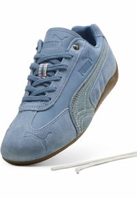 Jasnoniebieskie zamszowe sneakersy z denimu, teksturowana boczna panel, gumowa podeszwa i kontrastujące białe sznurowadła. Posiada logo na języku.