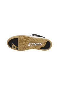 Black and white sneaker sole with a patterned rubber grip. Features a prominent "ETNIES" logo in white and a brown midsole.