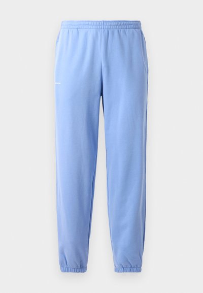 Light blue sweatpants with an elastic waistband, cuffed ankles, and side pockets. Features a small printed logo near the hip.