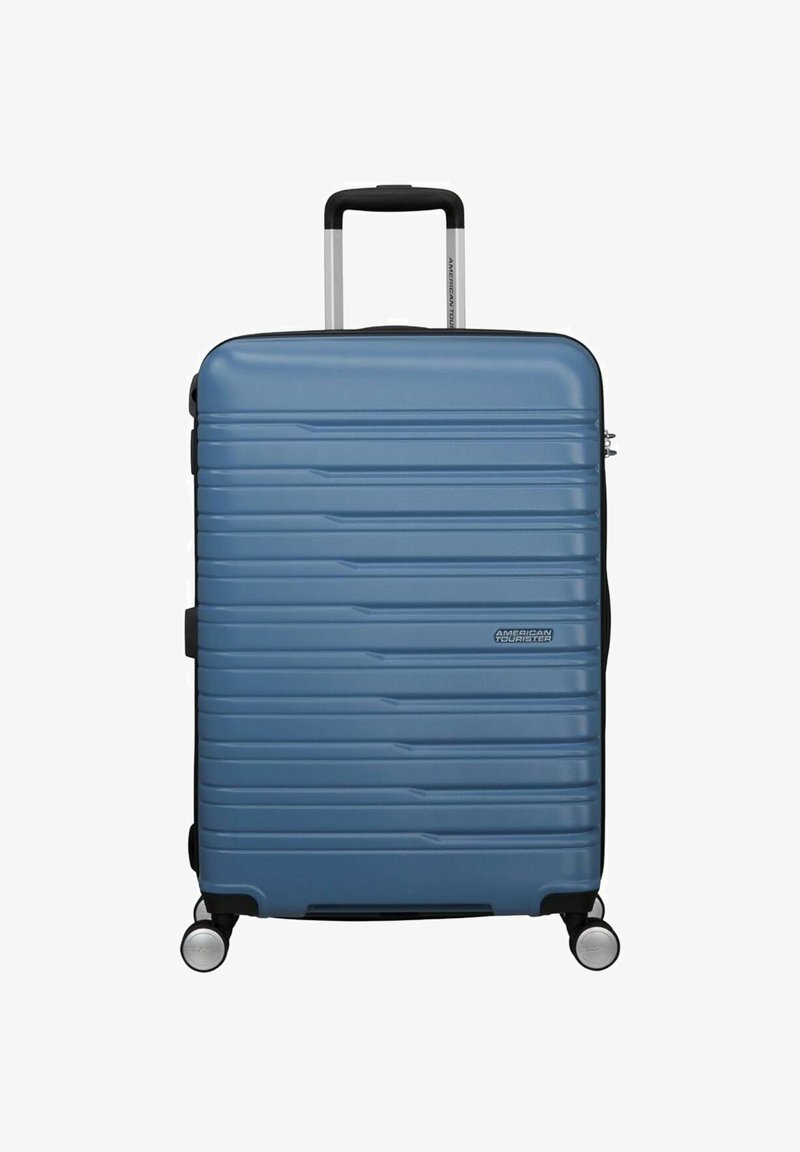 Maleta rígida de color azul con un diseño texturizado de estrías, asa retráctil y cuatro ruedas giratorias para mayor movilidad. Logotipo de la marca visible.