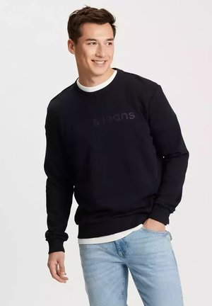 Czarny sweatshirt z okrągłym dekoltem z subtelnym logo "s.jeans", w połączeniu z jasnoniebieskimi dżinsami. Materiał wydaje się miękki, z prążkowanym dołem.