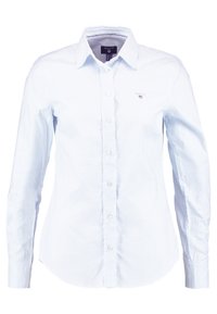 Camicia a maniche lunghe azzurro chiaro con strisce bianche verticali, chiusura con bottoni, colletto e piccolo logo ricamato sul petto.