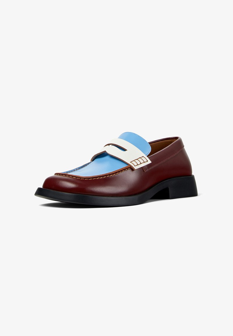 Mocassin en cuir marron avec un accent bleu et blanc sur la partie supérieure, semelle en caoutchouc noire et surpiqûres contrastantes le long des bords.