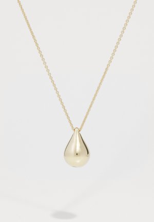 Gouden ketting met een druppelvormige hanger met een glad, glanzend oppervlak en een kleine zwarte stip, hangend aan een delicate ketting.