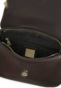 Interno di una borsa in pelle marrone con un scomparto con zip, hardware in tono oro e una fodera in tessuto con un motivo a logo.