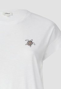 Witte katoenen t-shirt met een klein, geborduurd schildpaddendessin met kleurrijke patronen op zijn schild. Korte mouwen en ronde halslijn.