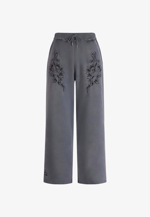 Pantalones de pierna ancha gris con cintura elástica y cordón, que presentan diseños bordados en negro de espadas y rosas en ambos lados. Textura de tela suave.