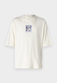 Kortærmet creme T-shirt lavet af bomuld, med et kvadratisk grafisk motiv af en gade i New York i centrum. Standard rund hals design.