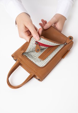 Braune Lederhandtasche mit zwei Tragegriffen, ausgestattet mit einem gemusterten Innenraum. Eine Reißverschlusstasche und eine glatte Textur vervollständigen ihr Design.