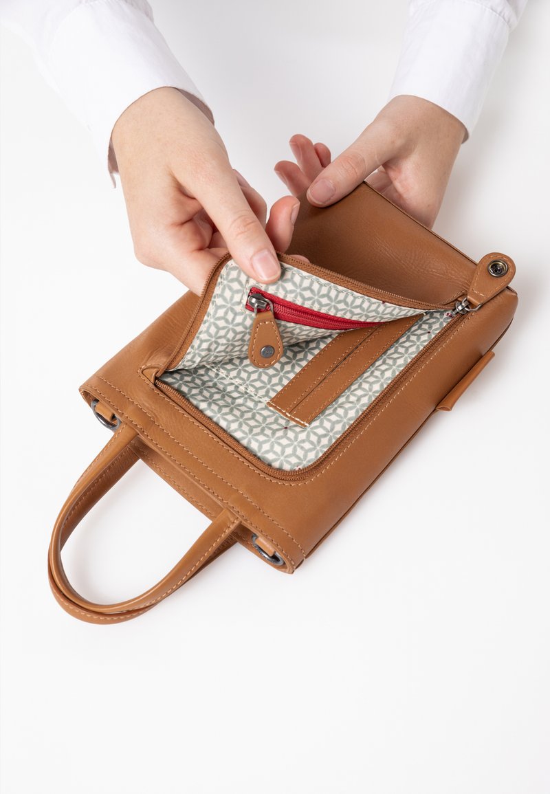 Braune Lederhandtasche mit zwei Tragegriffen, ausgestattet mit einem gemusterten Innenraum. Eine Reißverschlusstasche und eine glatte Textur vervollständigen ihr Design.