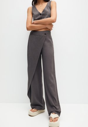 Haut cropped en lin gris avec un décolleté en V et des détails de boutons, associé à un pantalon à jambes larges avec un design enveloppant et un accent de bouton.