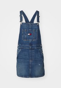 Jeansklänning, mörkblå, med justerbara remmar, framficka, knappstängningar och logopatch på bakfickan.