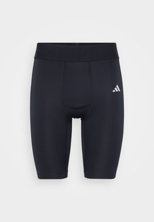 Black athletic shorts made of stretch fabric, featuring a snug fit, elastic waistband, and a small white logo on the left side.