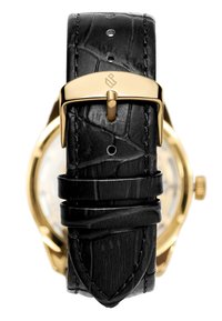 Sorte lærreim med krokodillemønster, med en gullfarget metallspenne og gravert logo, som sikrer en gullfarget urskive.