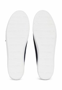Scarpe slip-on in tela navy con suole in gomma bianca. Le suole presentano strisce testurizzate e il nome del marchio in rilievo. Design pulito con accenti minimi.
