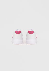 Sneakers bianche con dettagli rosa, caratterizzati da una superficie liscia, punte arrotondate e una suola in gomma bianca. Dettaglio del logo sul tallone.