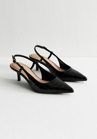 Talons aiguilles en cuir verni noir avec un bout pointu, motif crocodile texturé et un talon fin. Accent de boucle sur la sangle ajustable.