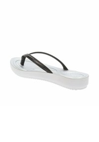 Infradito neri in gomma con una suola piatta e spessa bianca. Presentano un cinturino testurizzato e una superficie liscia. Progettate per un utilizzo casual.