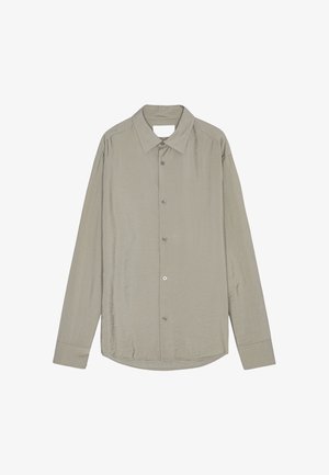 Camisa de manga larga de color gris claro con botones, cuello puntiagudo y puños estándar, exhibida extendida sobre un fondo blanco.