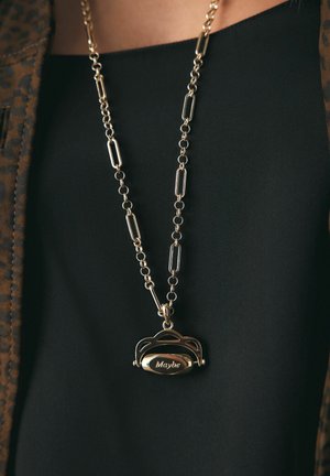 Gold chain necklace with rectangular and circular links, featuring a pendant engraved with the word "Maybe" over black clothing.