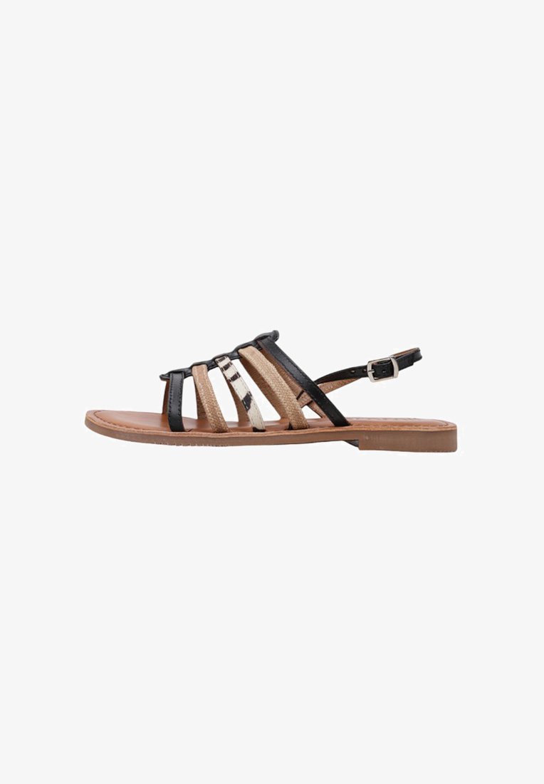 Sandalias de tiras con parte superior de textil negro y beige, con acentos metálicos. Suela plana, correa ajustable en el tobillo y diseño de punta abierta.