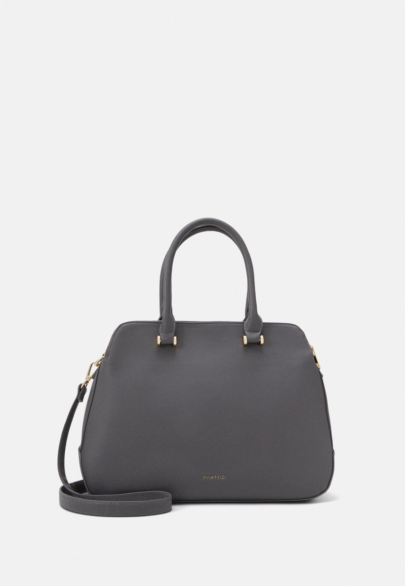 Gray synthetic handbag with dual handles, gold-tone hardware accents, and a detachable shoulder strap. Features a structured shape and logo detail.