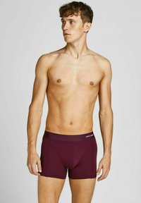 Bordeauxfarbene Boxershorts mit körpernahem Schnitt, weicher Stoff und einem flachen elastischen Bund mit weißem Branding.