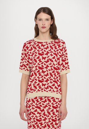 Rød og beige kortærmet top med et sommerfuglemønster, strikoverflade og kontrasterende ribkant ved krave og kant.