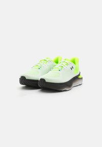 Zapatillas ligeras con parte superior de malla en verde neón y blanco, con suelas de goma negra y un diseño de cordones detallado.