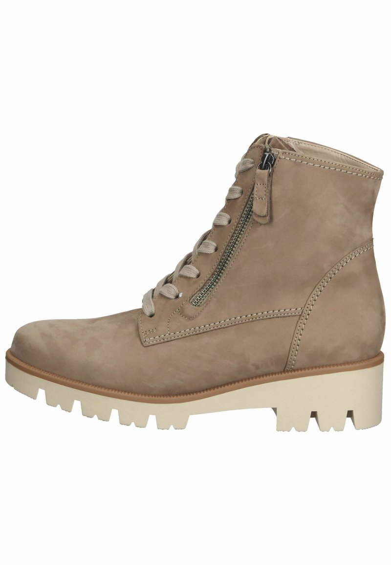 Bottines en suede beige, avec un laçage sur le devant, une fermeture éclair sur le côté, des détails cousus et une semelle blanche épaisse avec un bon grip.