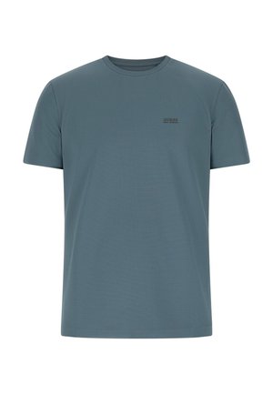T-shirt a maniche corte e girocollo in tessuto verde acqua smorzato con una consistenza liscia. Caratterizzata da un piccolo logo nero "GUESS" sul petto.