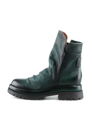 Bottine en cuir vert foncé avec dessus froissé, bout rond, col rembourré et semelle épaisse noire à crampons, vue de profil sur fond blanc.