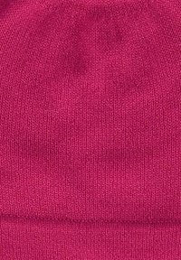 Berretto in maglia di un vivace colore rosa, con una texture morbida e orlo ripiegato. Il design è semplice, senza ulteriori motivi o accessori.