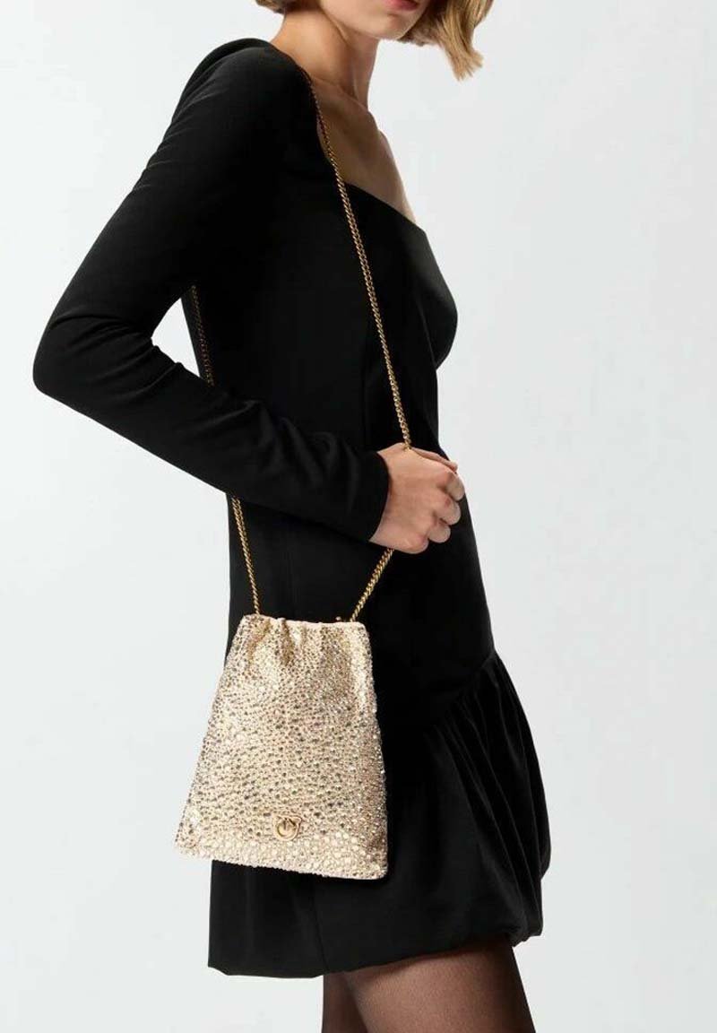 Borsa a secchiello dorata con paillettes e chiusura a coulisse, dotata di una sottile tracolla a catena. La borsa ha una forma triangolare strutturata e una texture lucida.