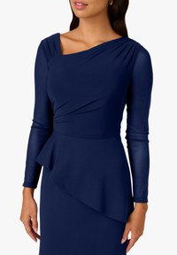 Granatowa sukienka z długimi rękawami, asymetrycznym dekoltem, plisowanym detalem na ramieniu oraz dopasowanym pasem z baskinką.
