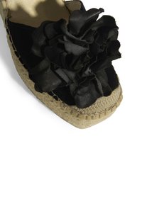 Schwarze Espadrille mit oberer Schicht aus strukturiertem Stoff und Lederblumenakzent, ausgestattet mit einer geflochtenen Jutesohle und beigen Nähdetails.