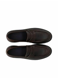 Mocassins en cuir marron avec une texture lisse, dotés d'un bout pointu et d'une couture décorative sur le devant. Design simple à enfiler.