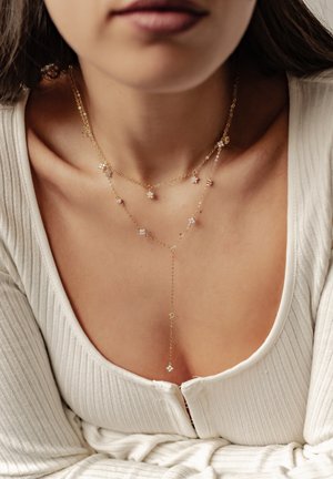 Vergoldete Halskette mit Stern- und runden Anhängern, ausgestattet mit einem zarten Kettendesign. Die Halskette im Lariat-Stil hat hängende Akzente.